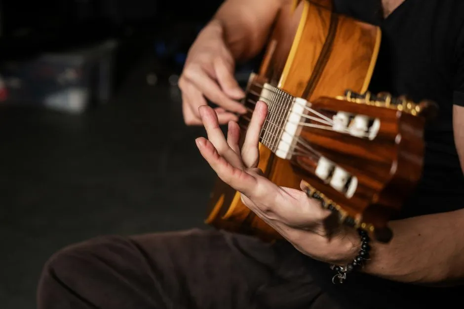 Close-up of a person's hands fretting and strumming an acoustic guitar